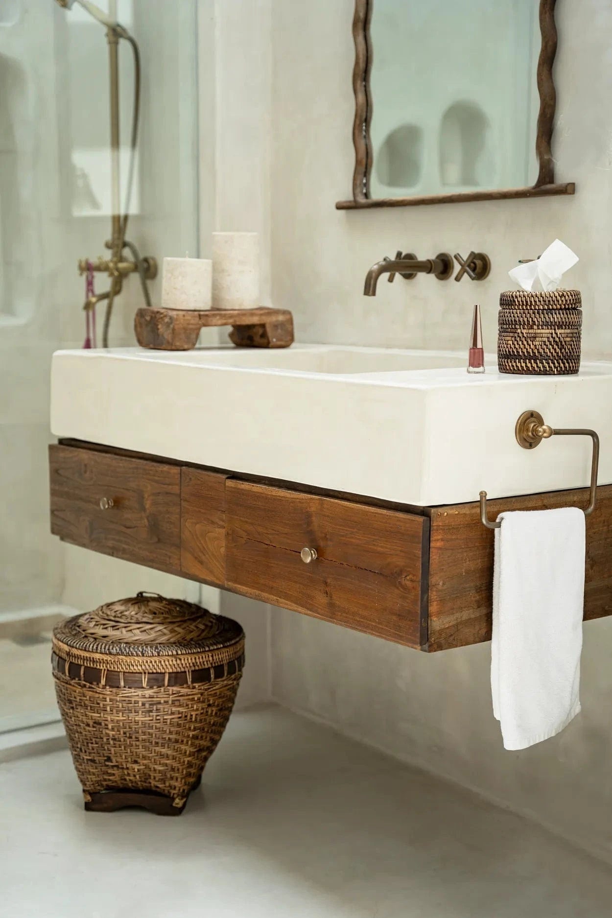 Bathroom vanity with wooden cabinet, white countertop, and wicker basket.