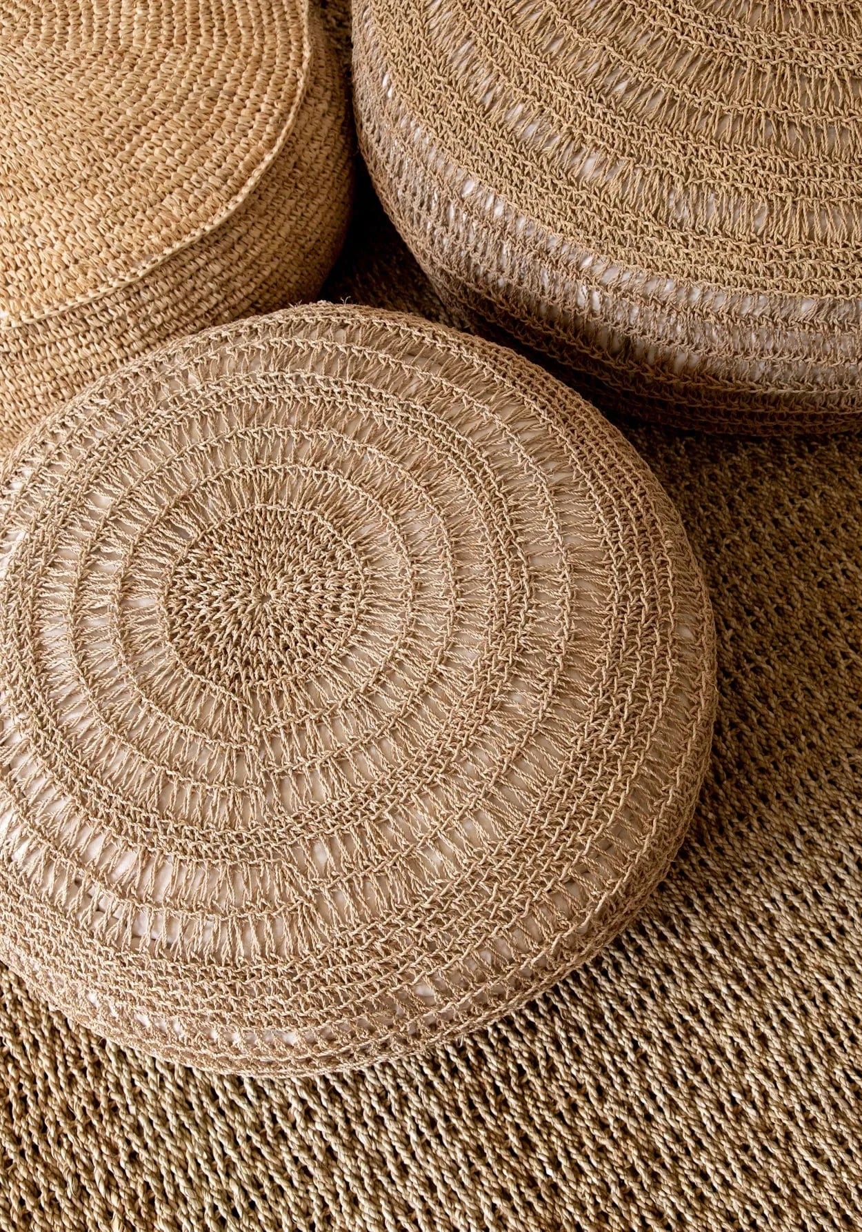 Close-up of woven round ottomans with a textured surface.