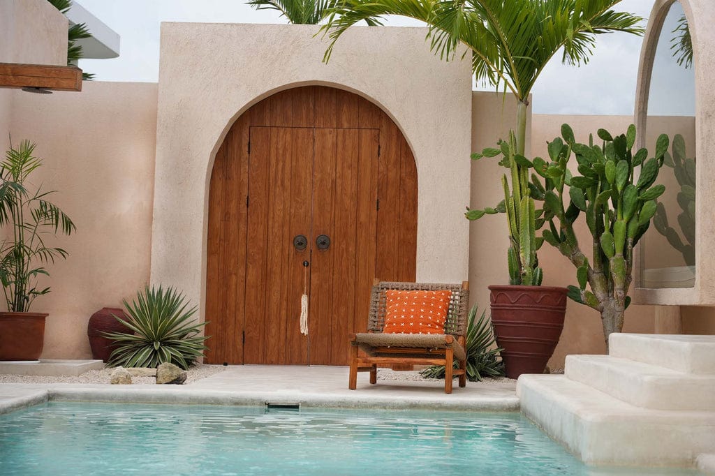 Terracotta white cotton Zillion Kiss Cushion Cover on poolside chair near door entrance