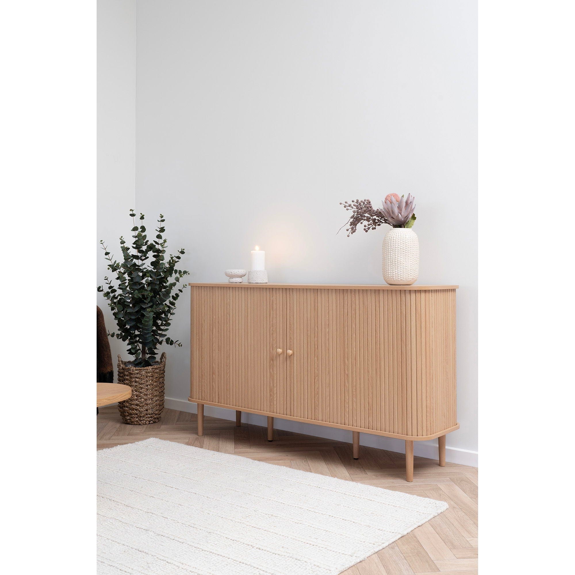 Wooden sideboard with decorative items in a minimalistic room