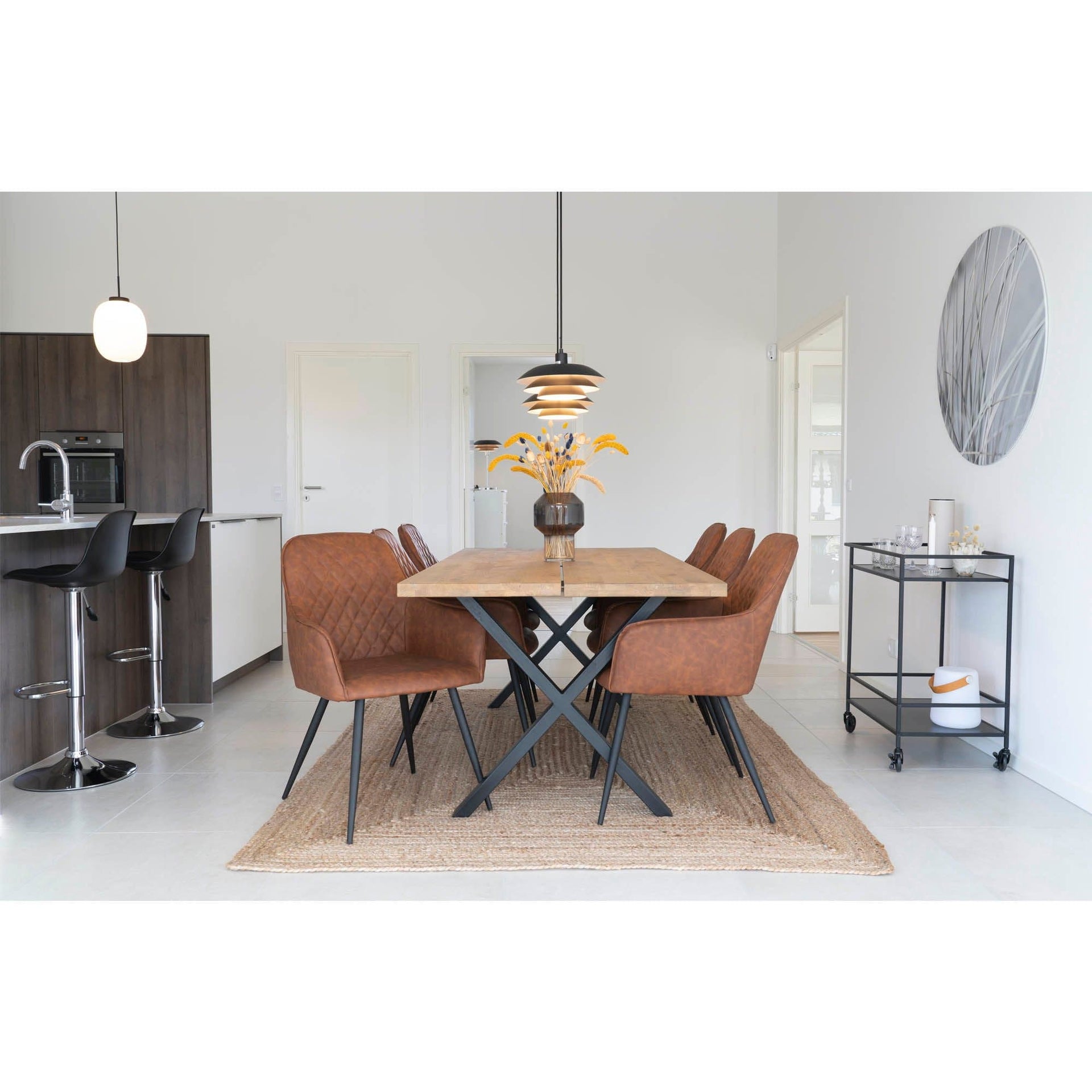 Modern kitchen and dining area with wooden table and brown chairs.