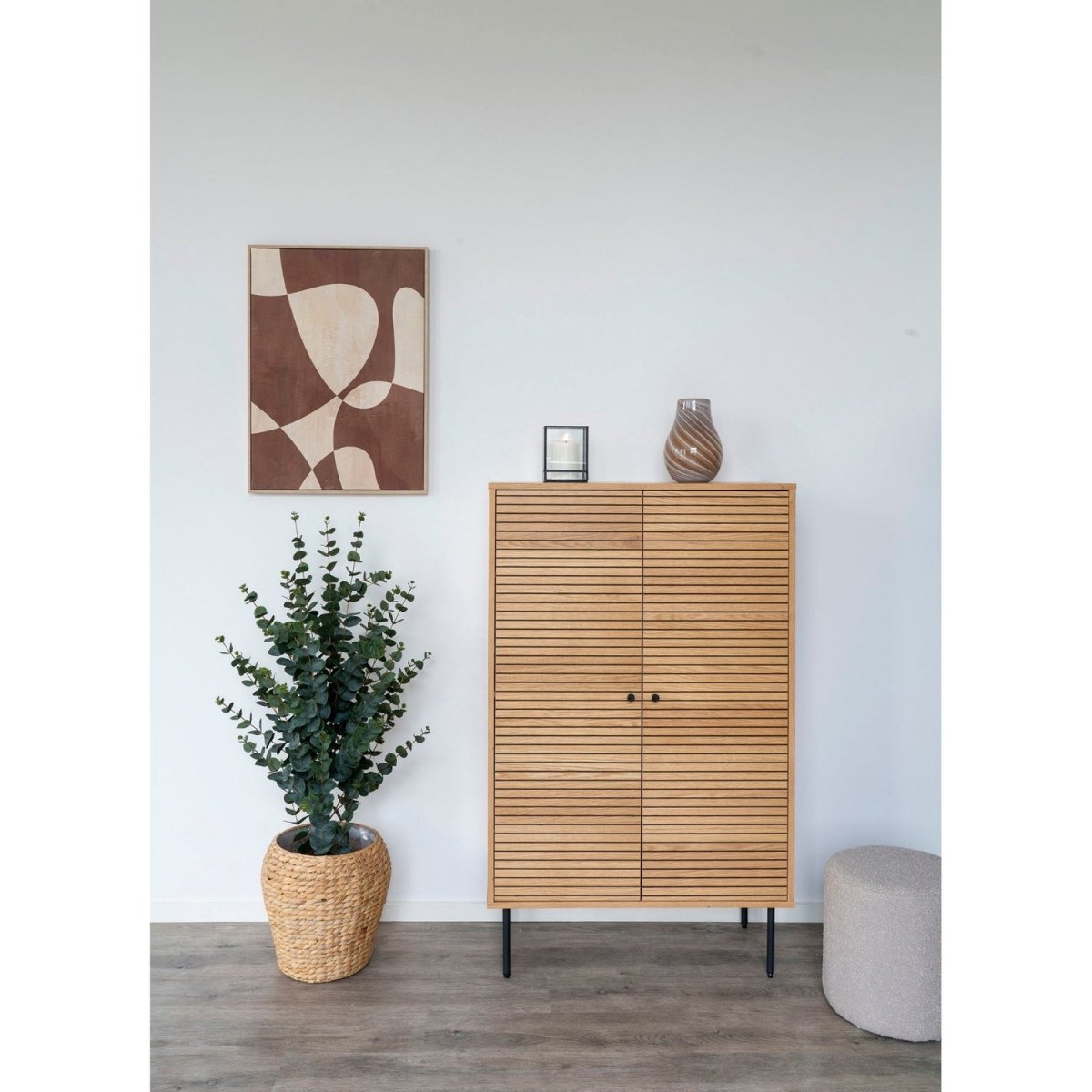 Wooden cabinet with a plant and decorative items in a room setting