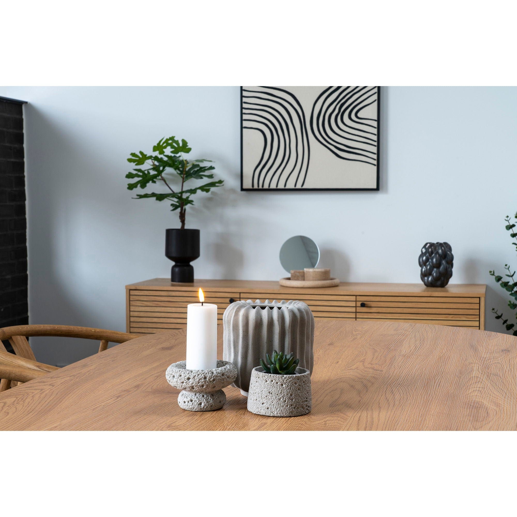 Modern interior with a wooden table, candle, and decorative items.