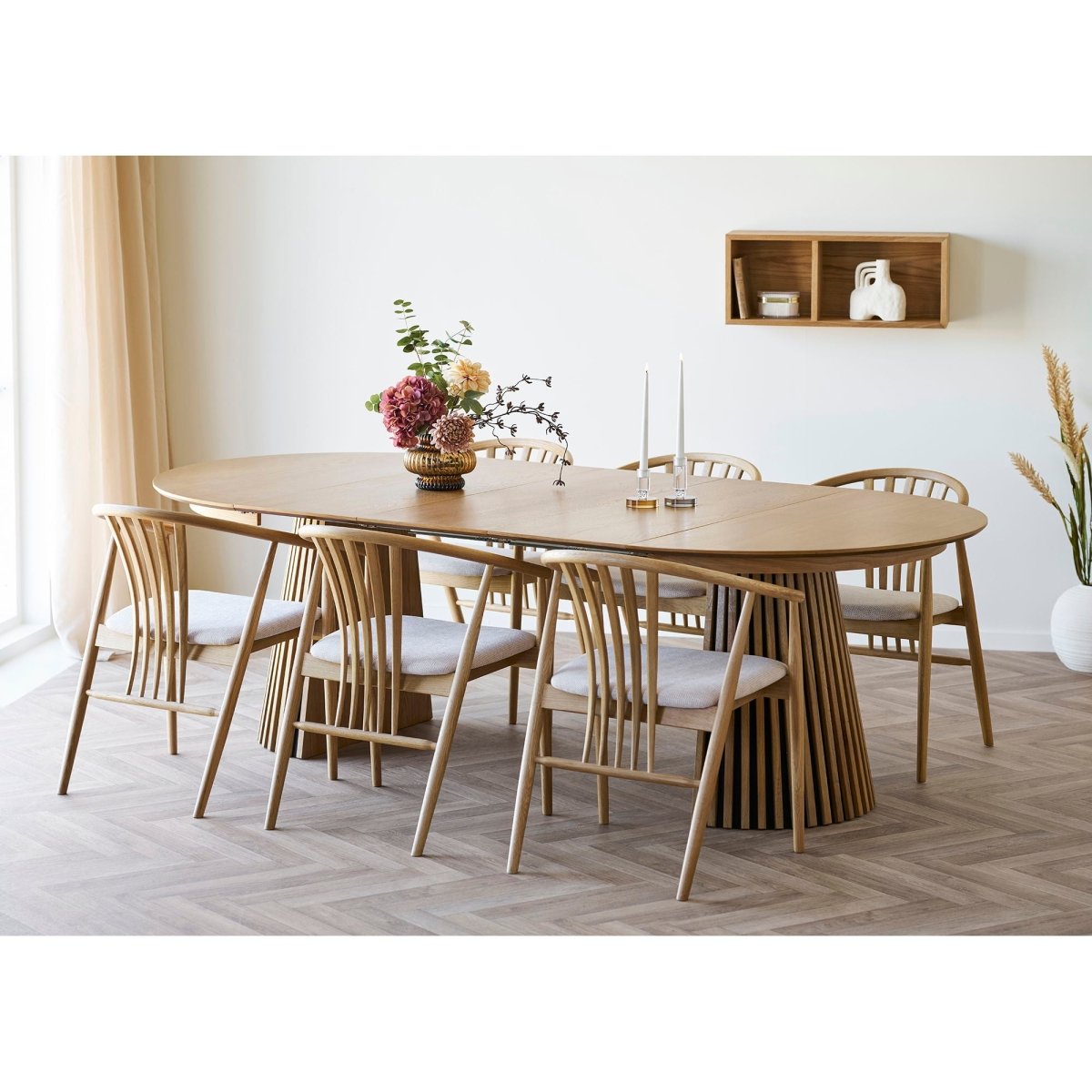 Dining room with wooden table and chairs on a herringbone floor.