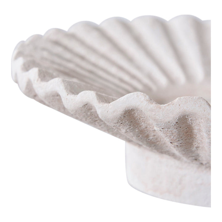 Close-up of a textured white dish on a white background.