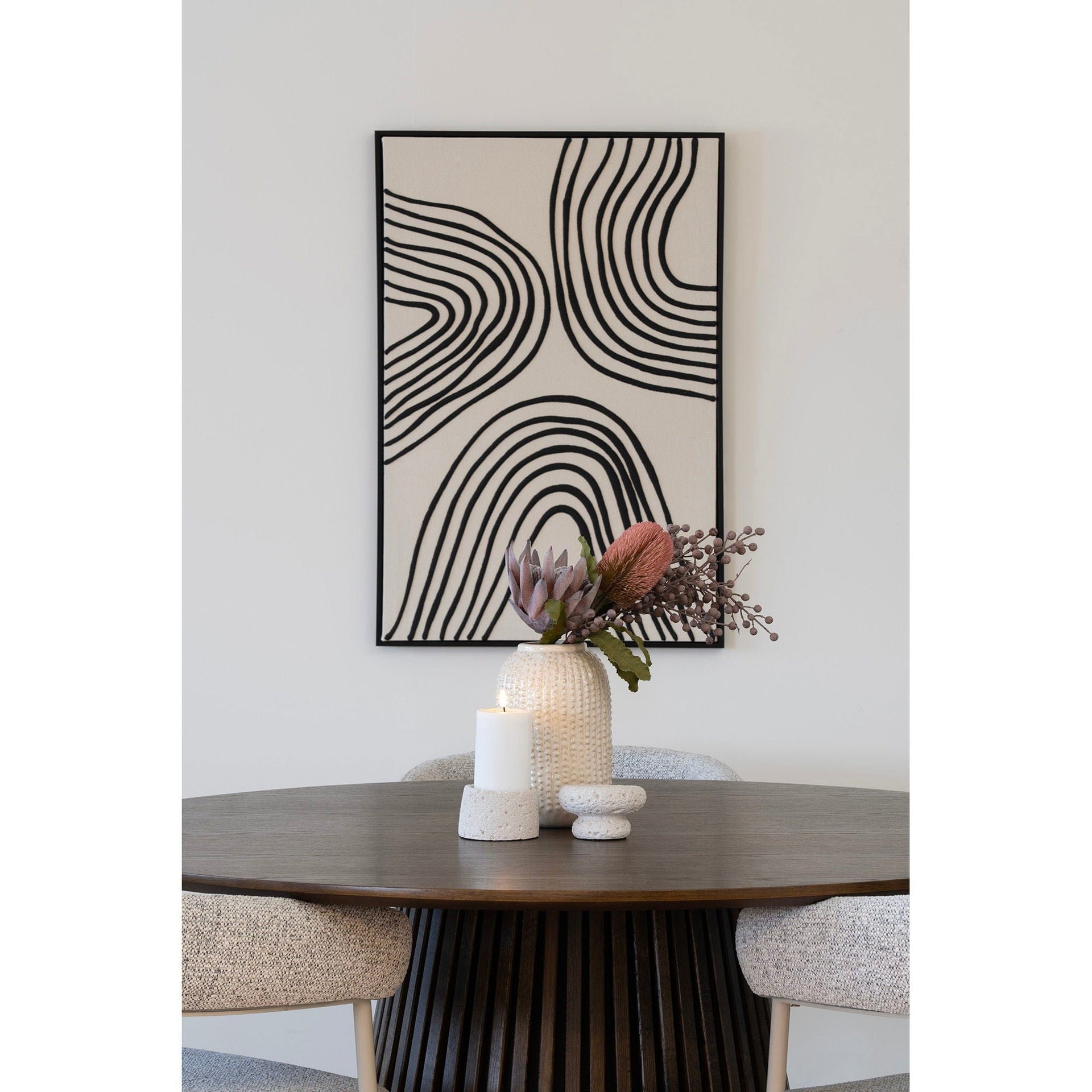 Modern abstract art above a table with decorative items.