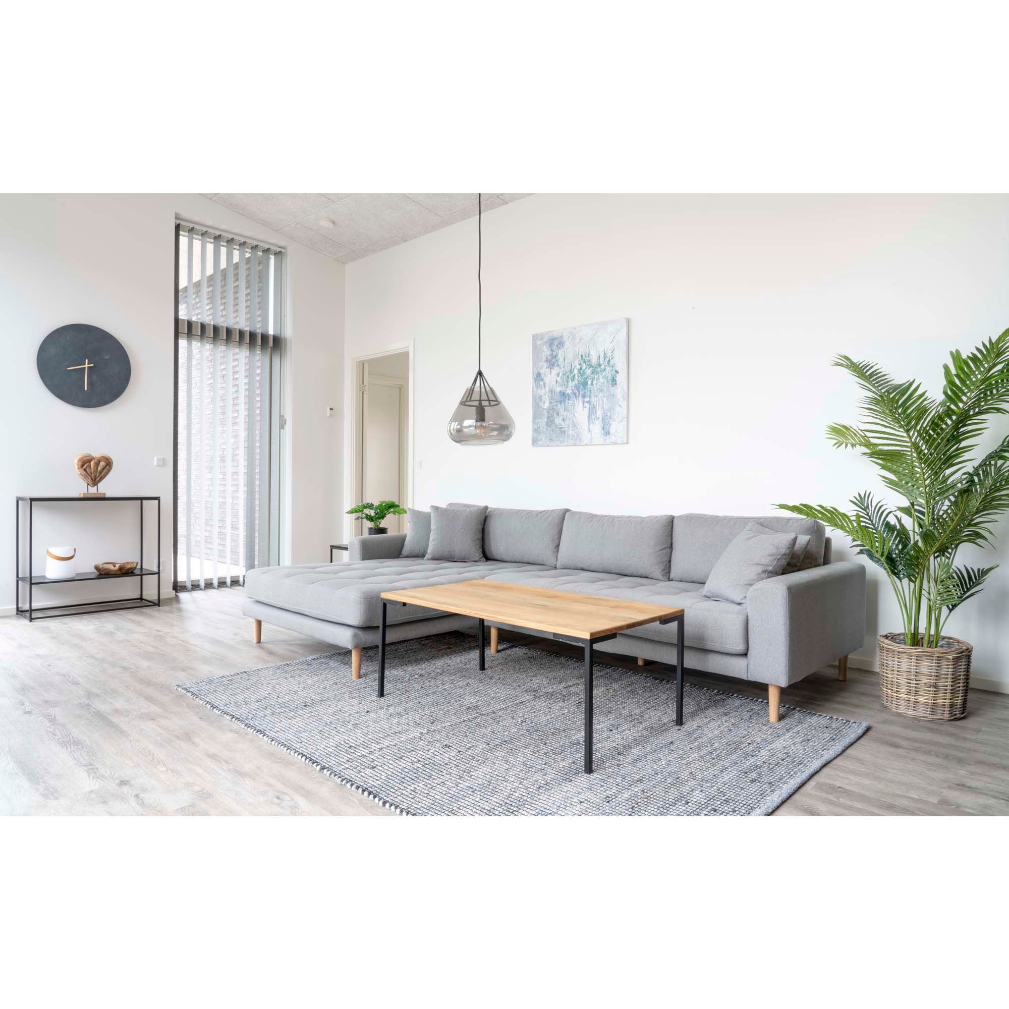 Modern living room with a gray sectional sofa, wooden coffee table, and decorative elements.