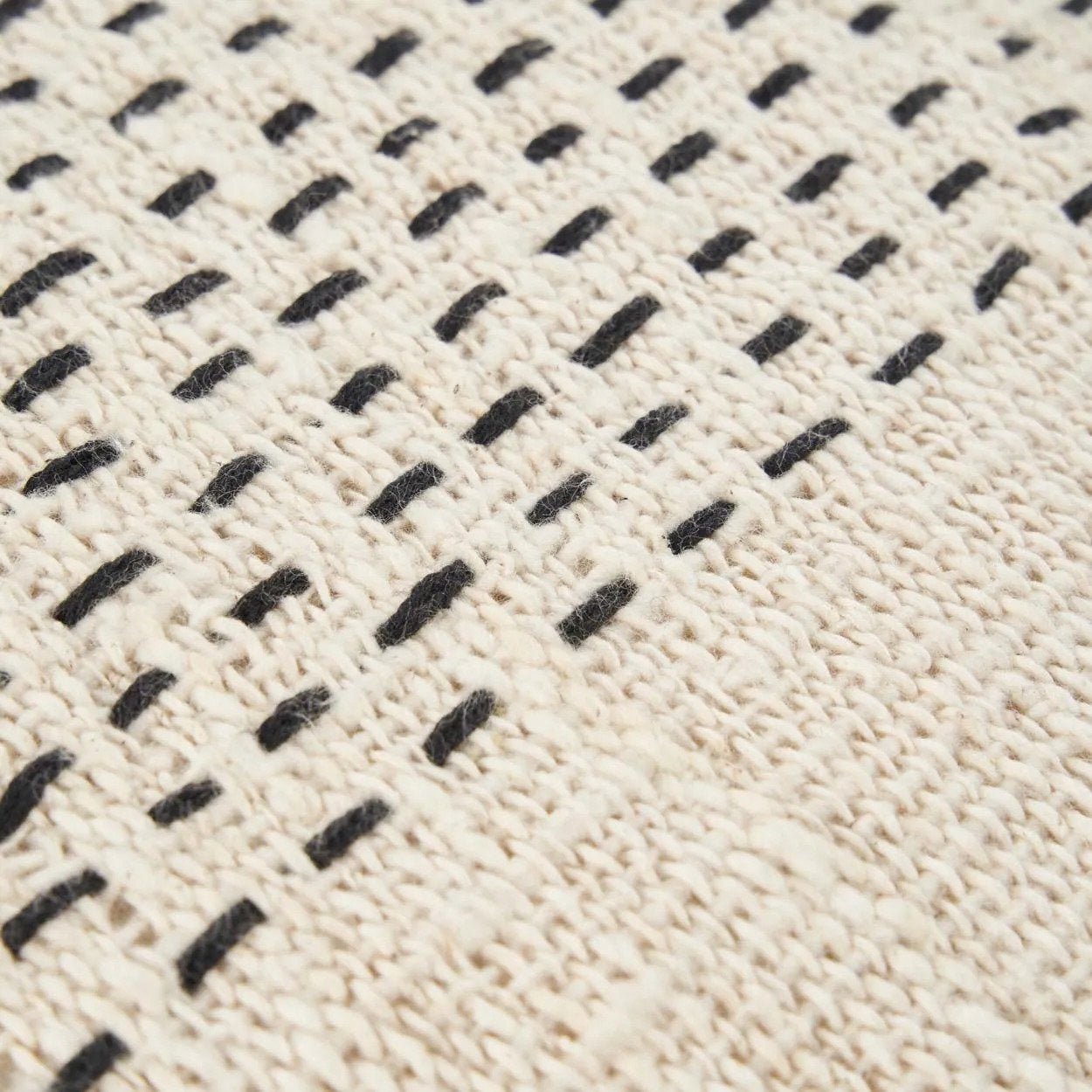 Close-up of a textured fabric with black woven pattern