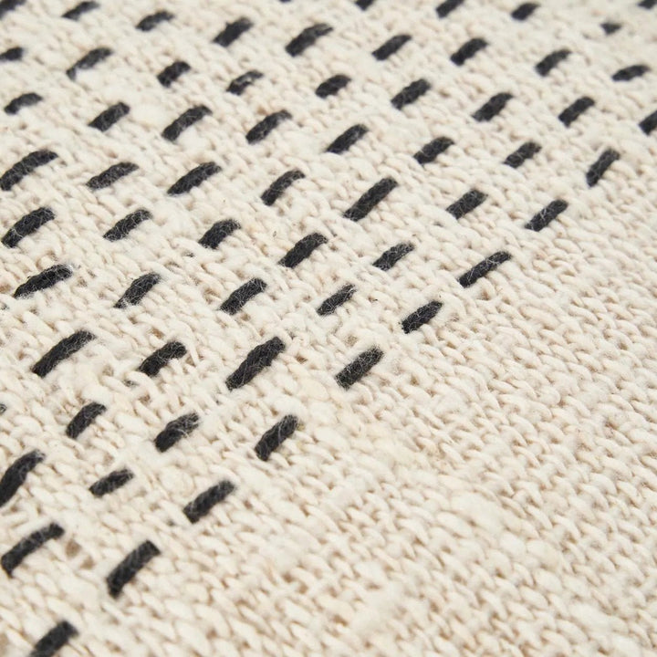 Close-up of a textured fabric with black woven pattern