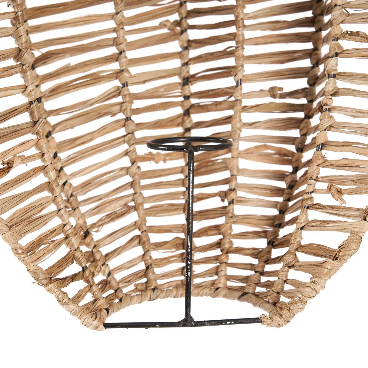 Woven rattan wall art with a black metal stand on a white background