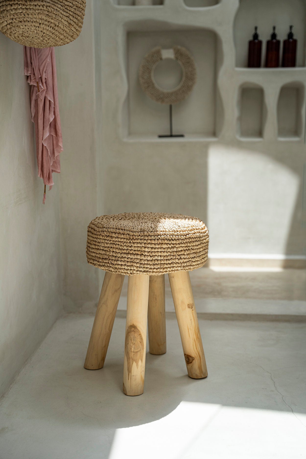 Woven stool with wooden legs in a minimalistic room setting