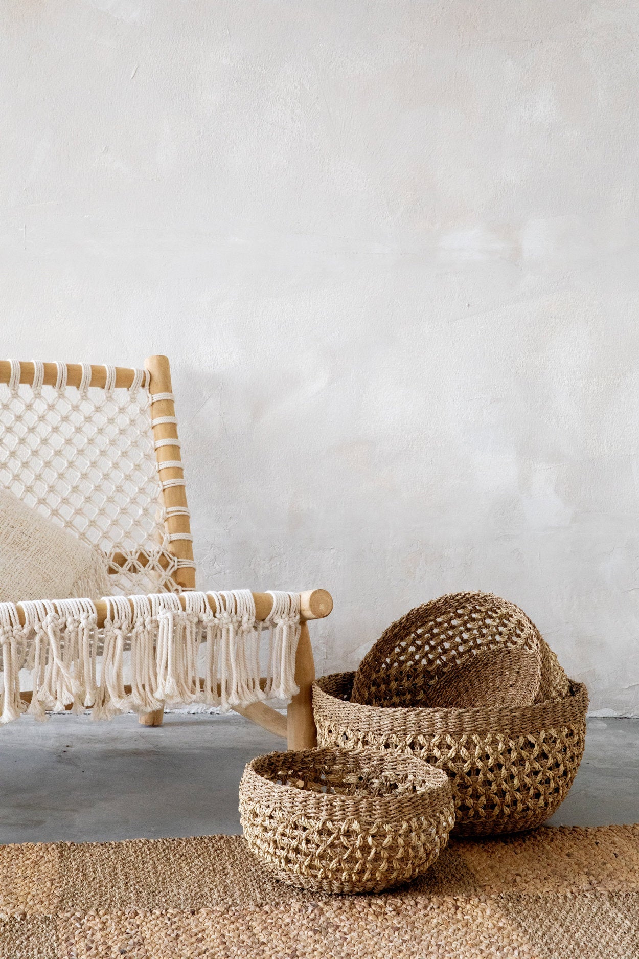 Woven baskets and a chair with macrame details on a neutral background