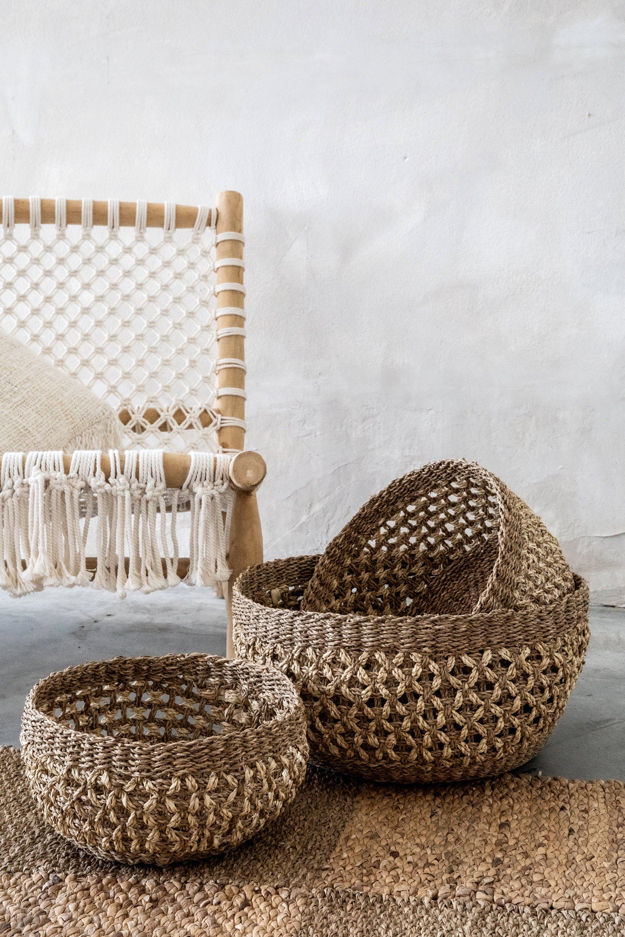 Woven baskets on a textured surface with a chair in the background
