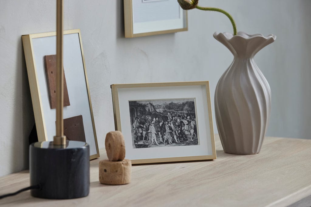 Austin Photo Frame in light gold, 20 cm x 15 cm, displayed on a wooden surface with decor items.
