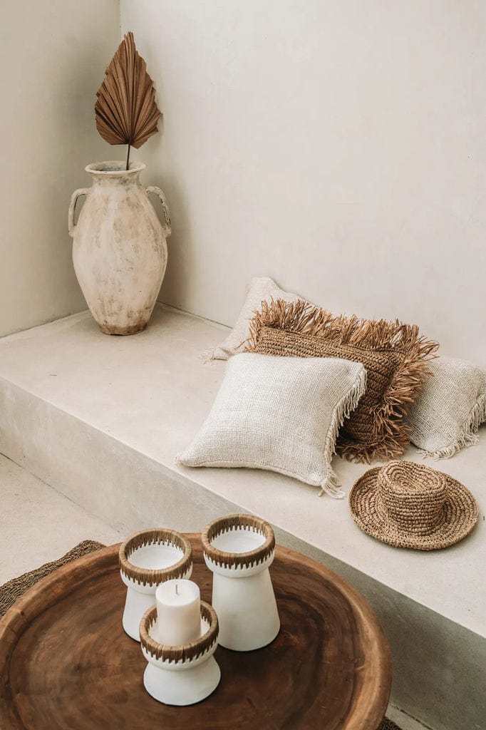 Pretty candle holder - white terracotta with raffia accent on table.