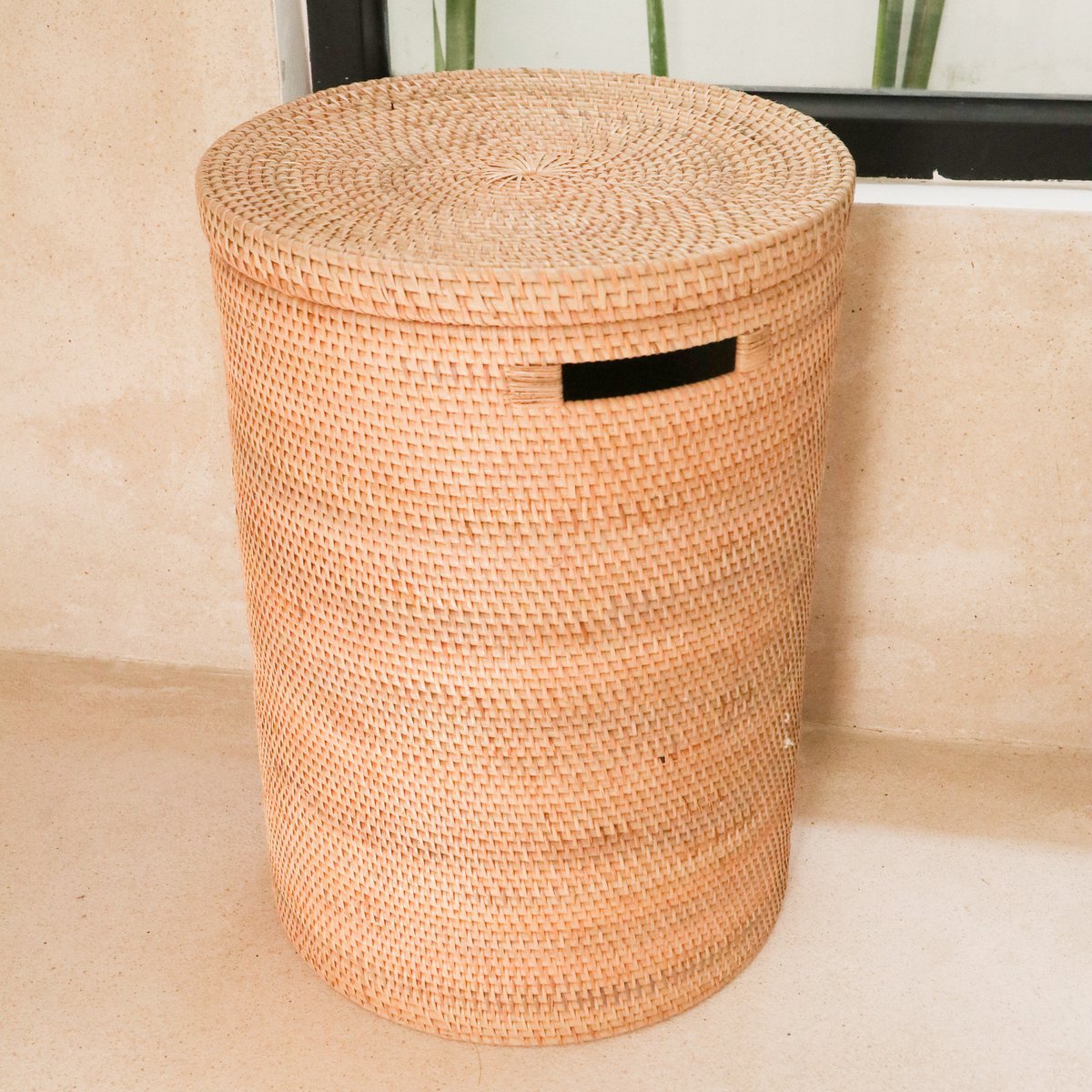 Woven basket with a lid on a neutral background