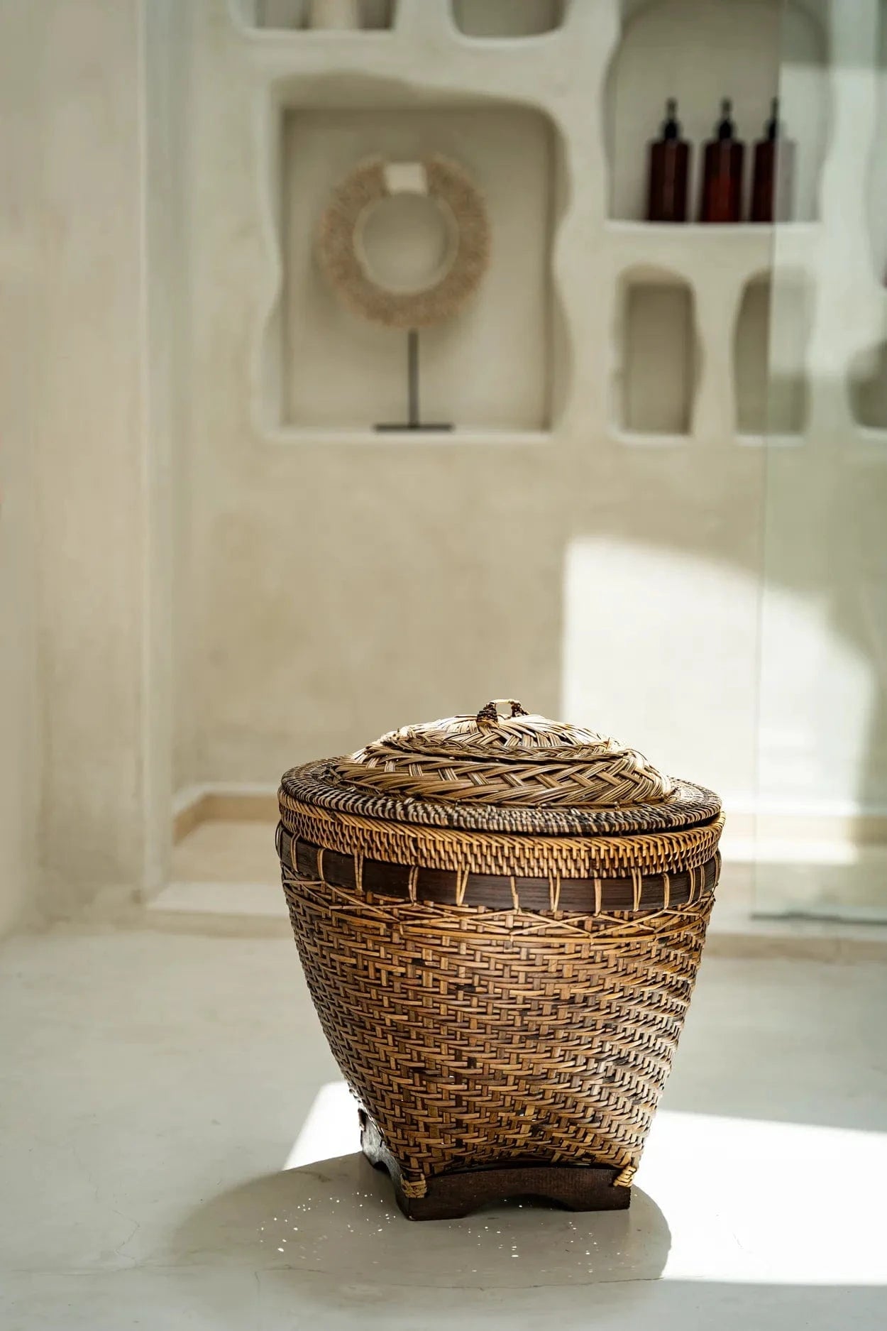 Woven basket with a lid on a light surface with a neutral background