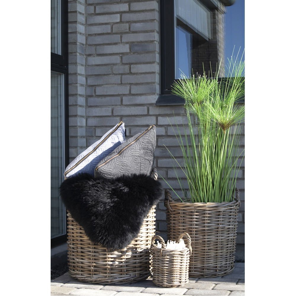 Wicker baskets with decorative items against a brick wall