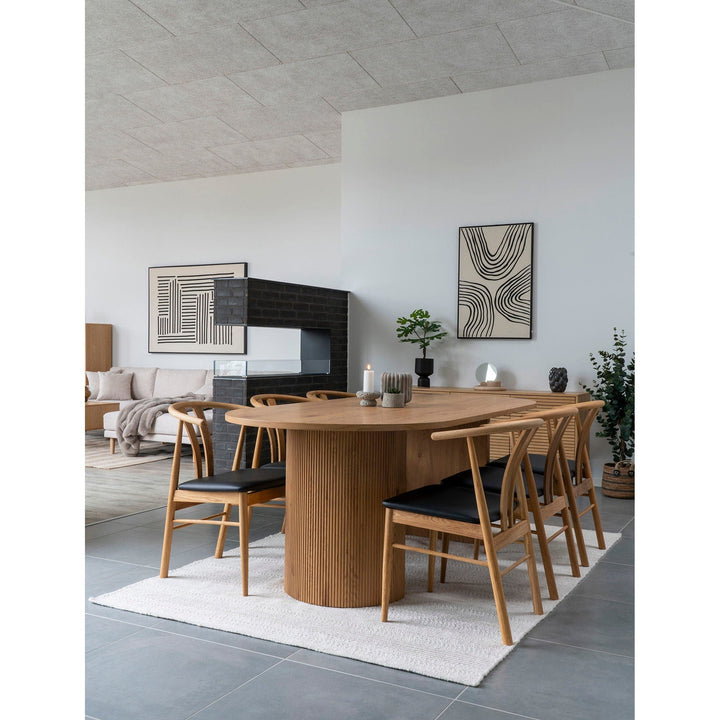 Dining room with wooden table and chairs in a modern interior setting.