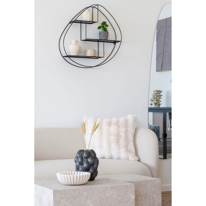 Modern living room with a white sofa, decorative pillows, and a wall shelf.