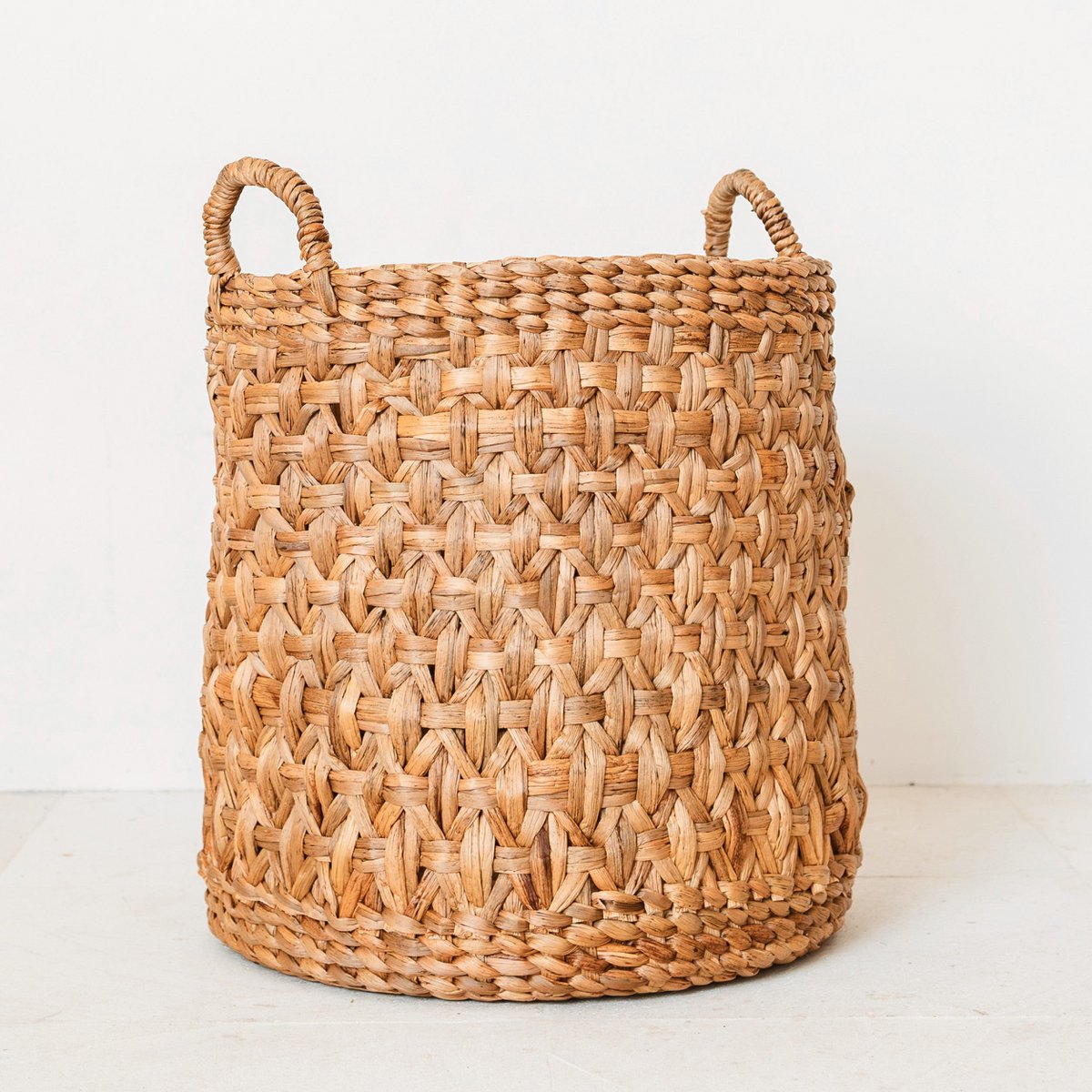 Woven basket with handles on a white background