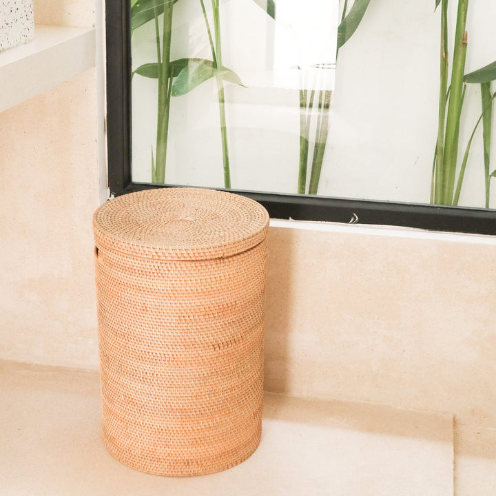 Woven storage basket with a lid on a light wooden floor.