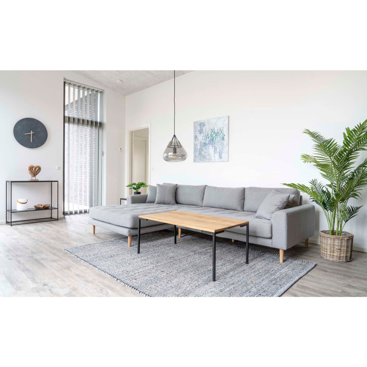 Modern living room with a gray sectional sofa, wooden coffee table, and decorative elements.