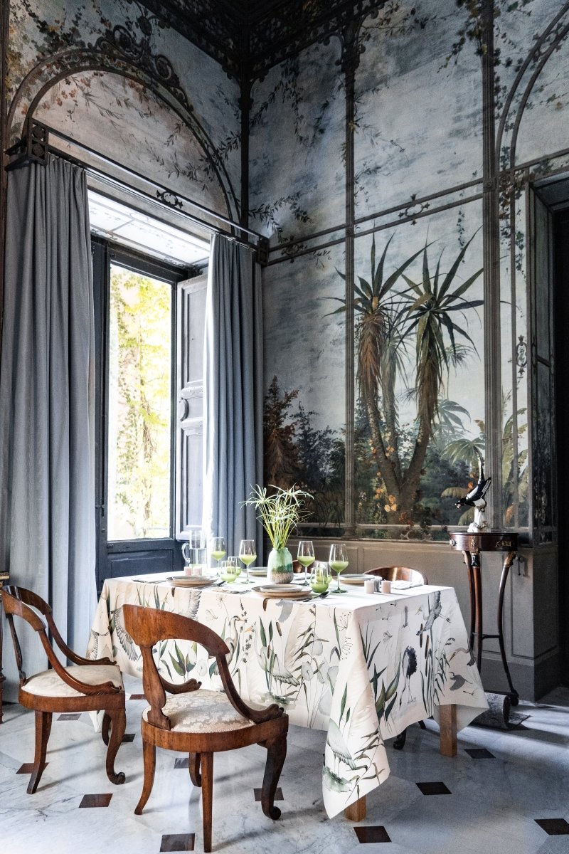 Dining room with ornate walls, table set for a meal, and decorative elements.