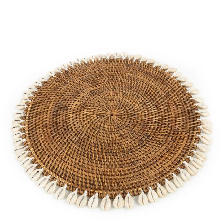Round woven placemat with shell trim on a white background