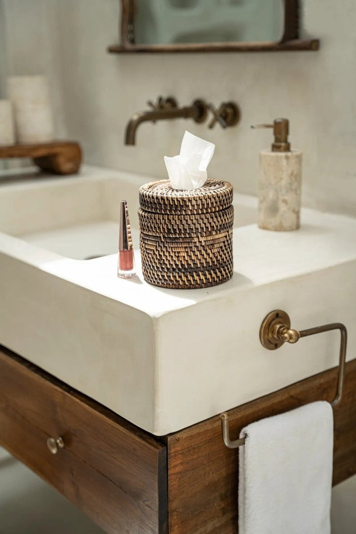 Bathroom vanity with a woven basket, soap dispenser, and other items on a white countertop.