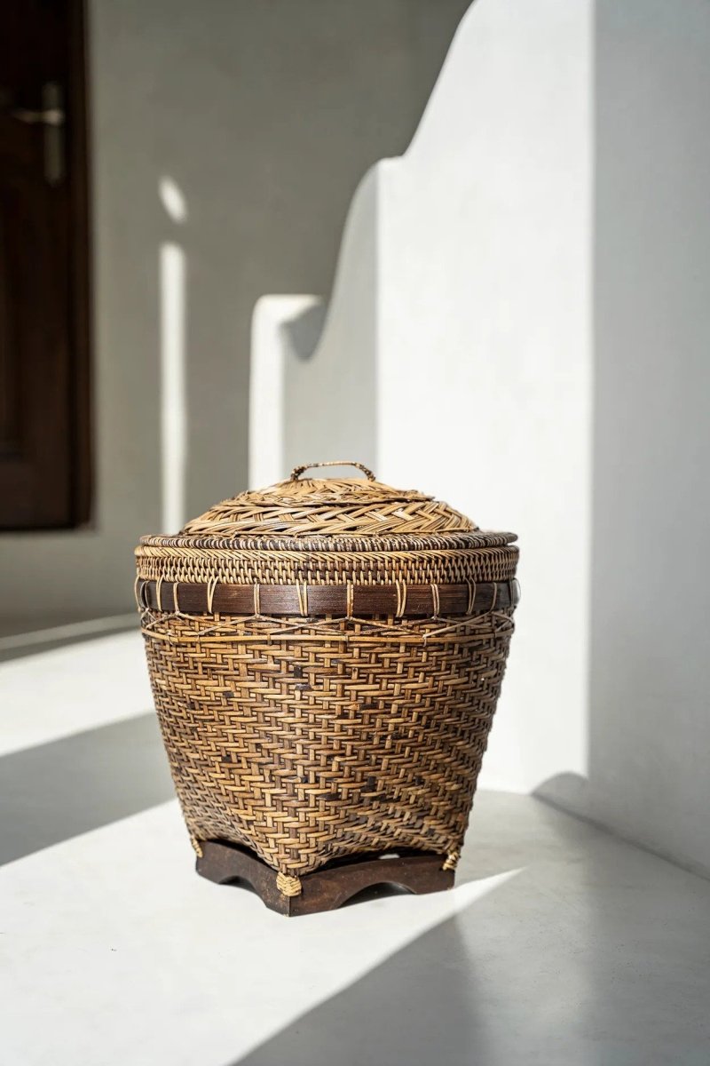 Woven basket with a lid on a white surface