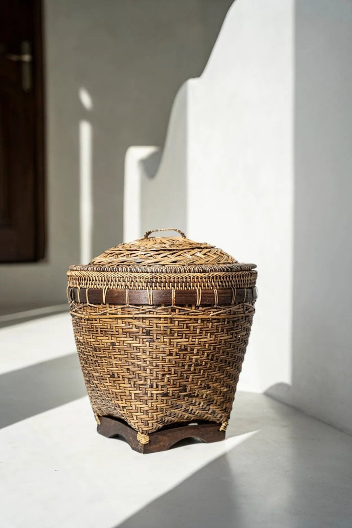 Woven basket with a lid on a white surface