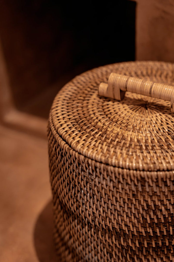 Woven basket with a lid on a brown background
