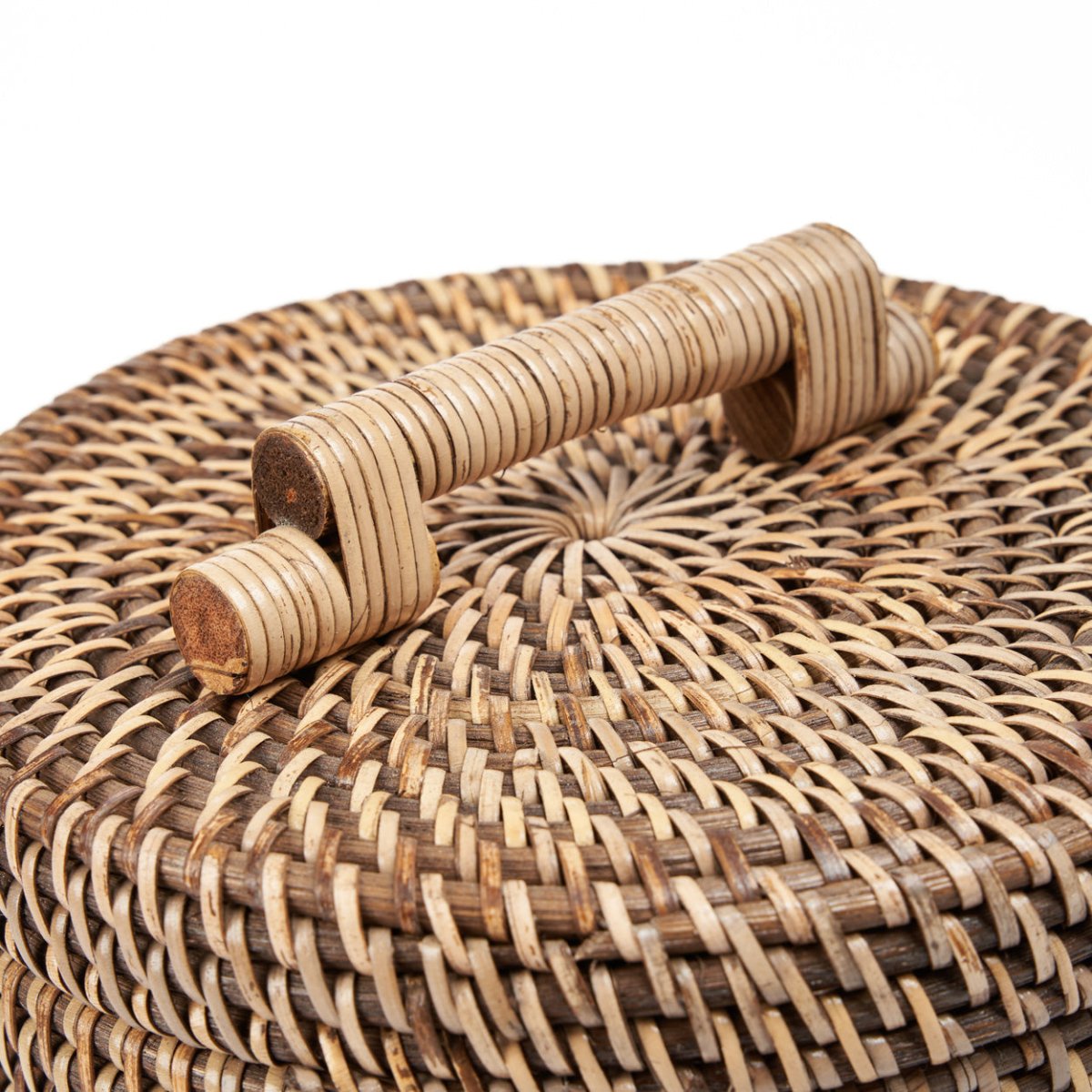 Close-up of a woven rattan box with wooden handles on a white background