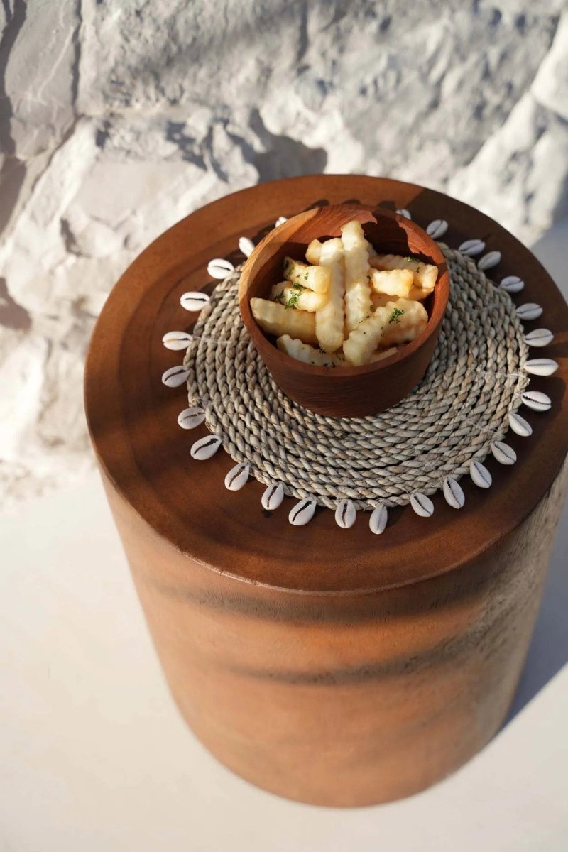 Wooden container with a woven lid on a textured surface