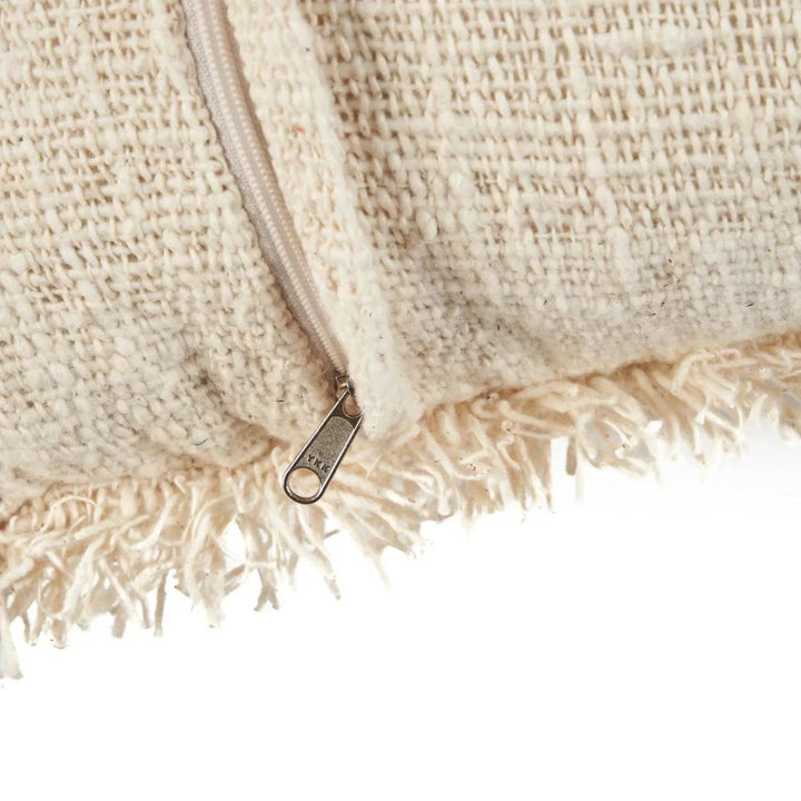 Close-up of a textured beige fabric with a zipper on a white background