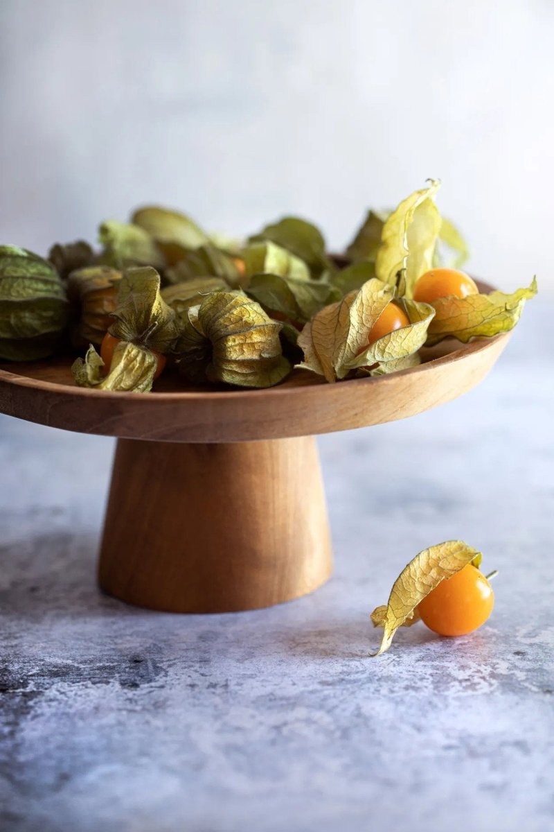 Wooden stand withPhysalis fruit on a marble surface
