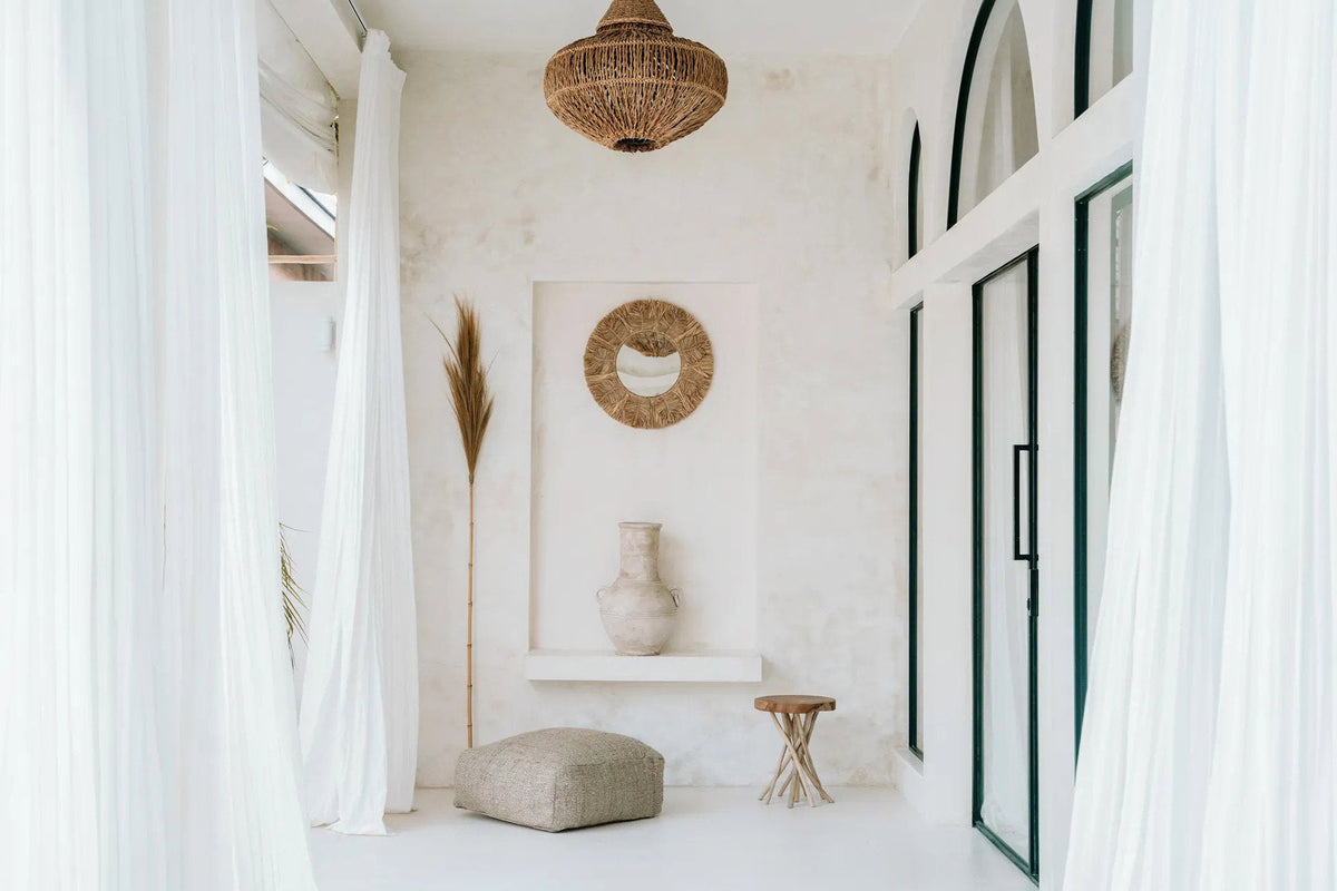 Modern interior with white walls, a textured pendant light, and decorative elements.