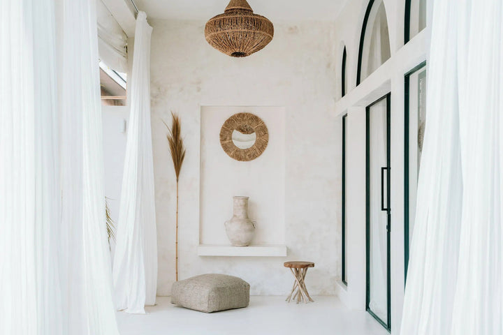 Modern interior with white walls, a textured pendant light, and decorative elements.