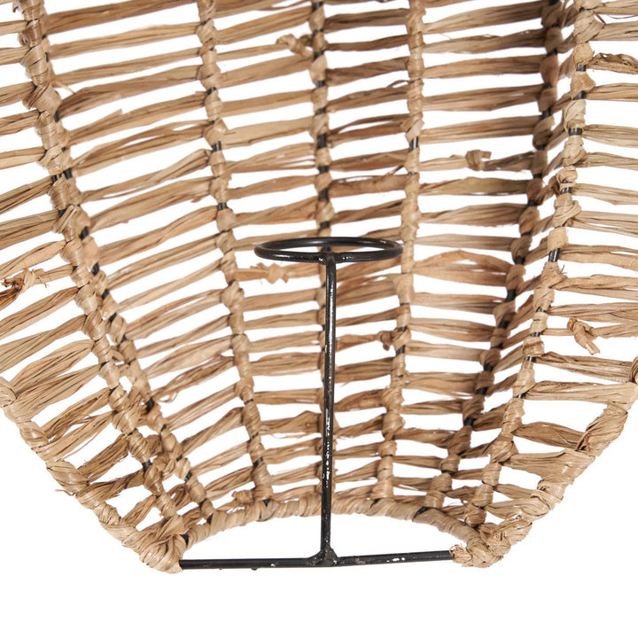 Woven rattan wall art with a black metal stand on a white background