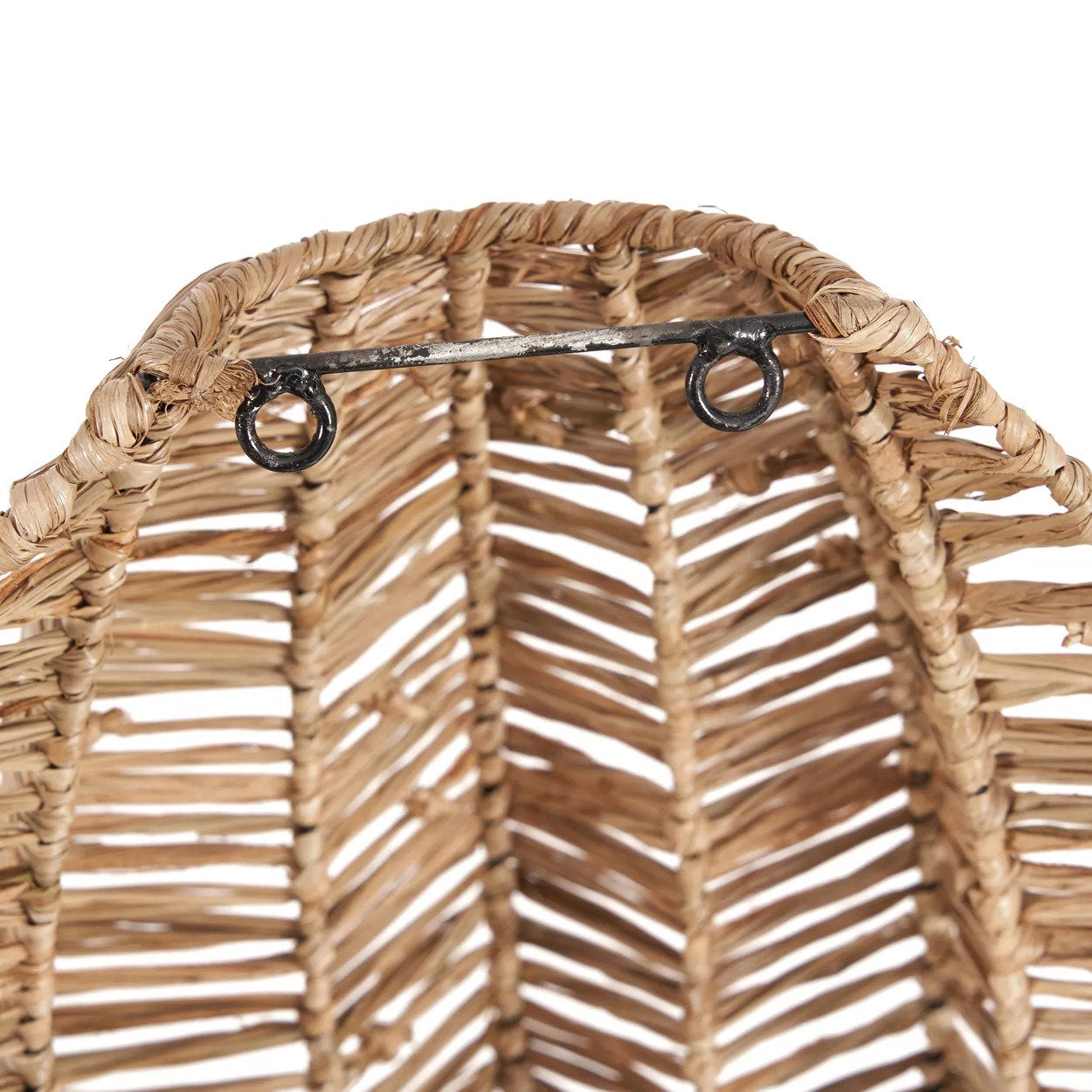 Close-up of a woven basket with a metal handle on a white background