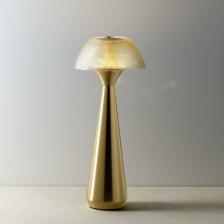 Gold table lamp with textured shade on a plain background
