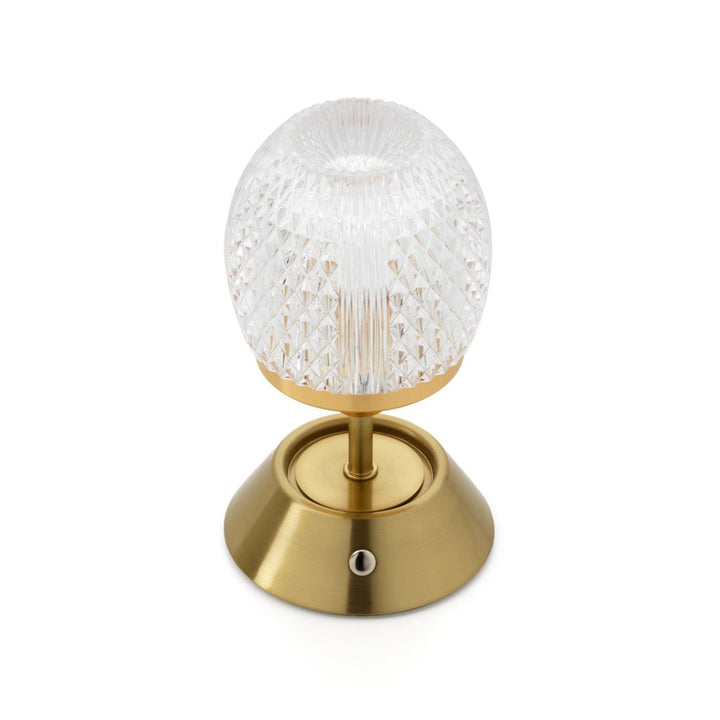 Decorative lamp with a gold base and textured glass shade on a white background