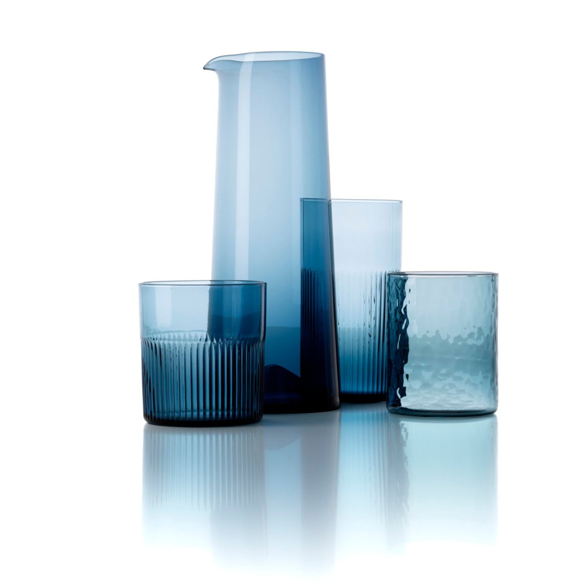 Set of blue glassware including a pitcher and three glasses on a white background