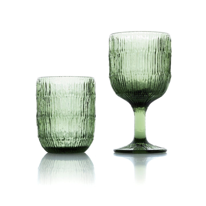 Two green glass tumblers with textured surfaces on a white background