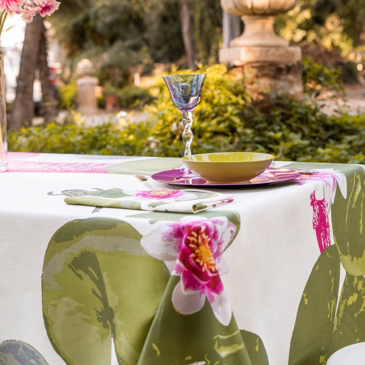 Table setting with floral tablecloth and glass in an outdoor garden setting
