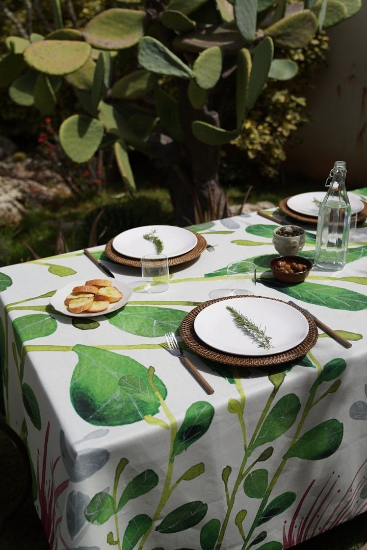 Table setting with a leaf-patterned tablecloth outdoors