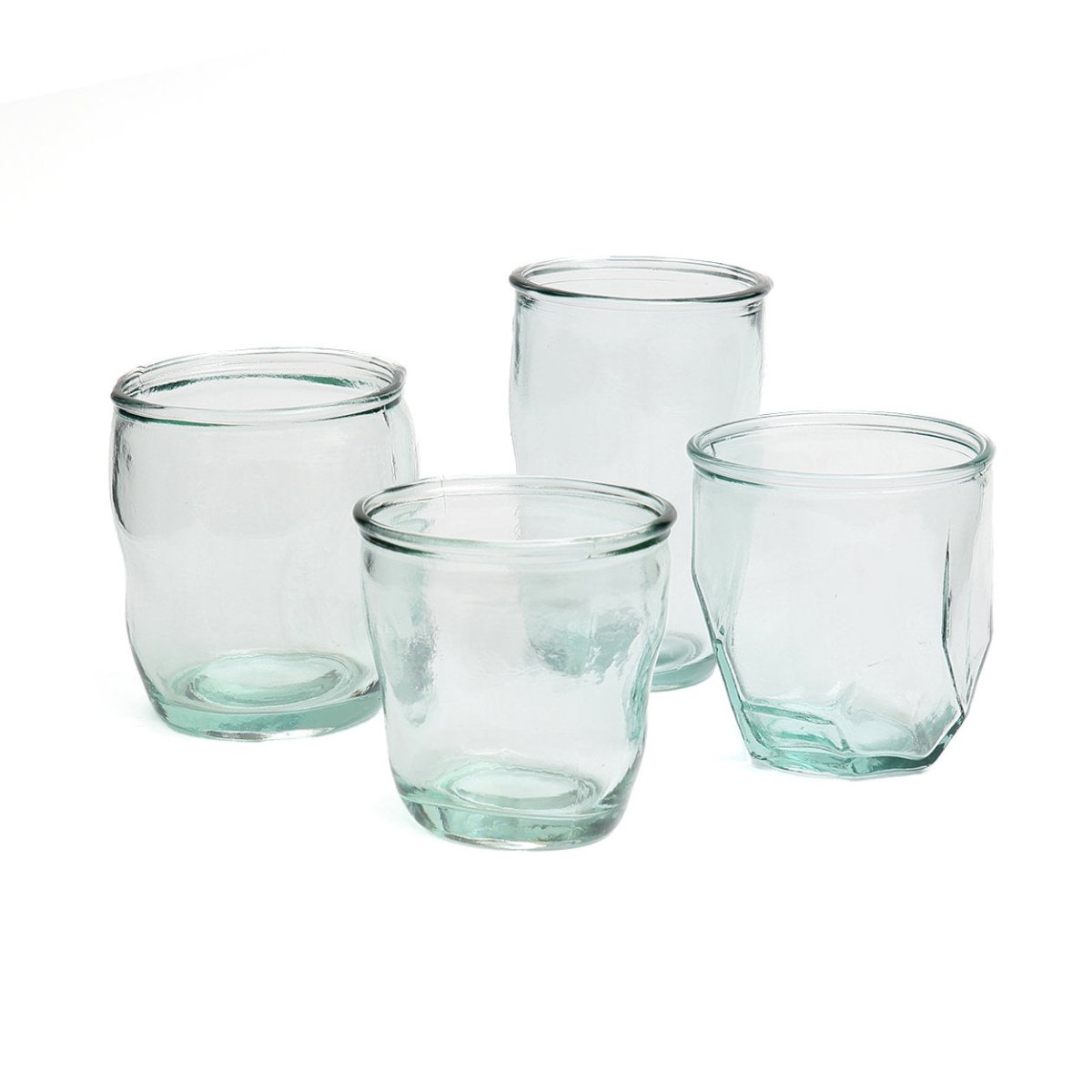 Set of four clear glass tumblers on a white background