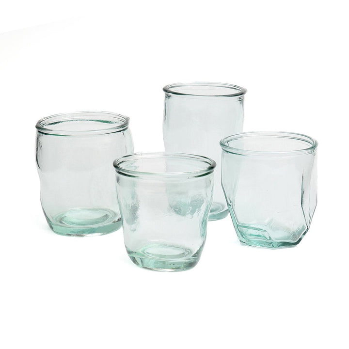 Set of four clear glass tumblers on a white background