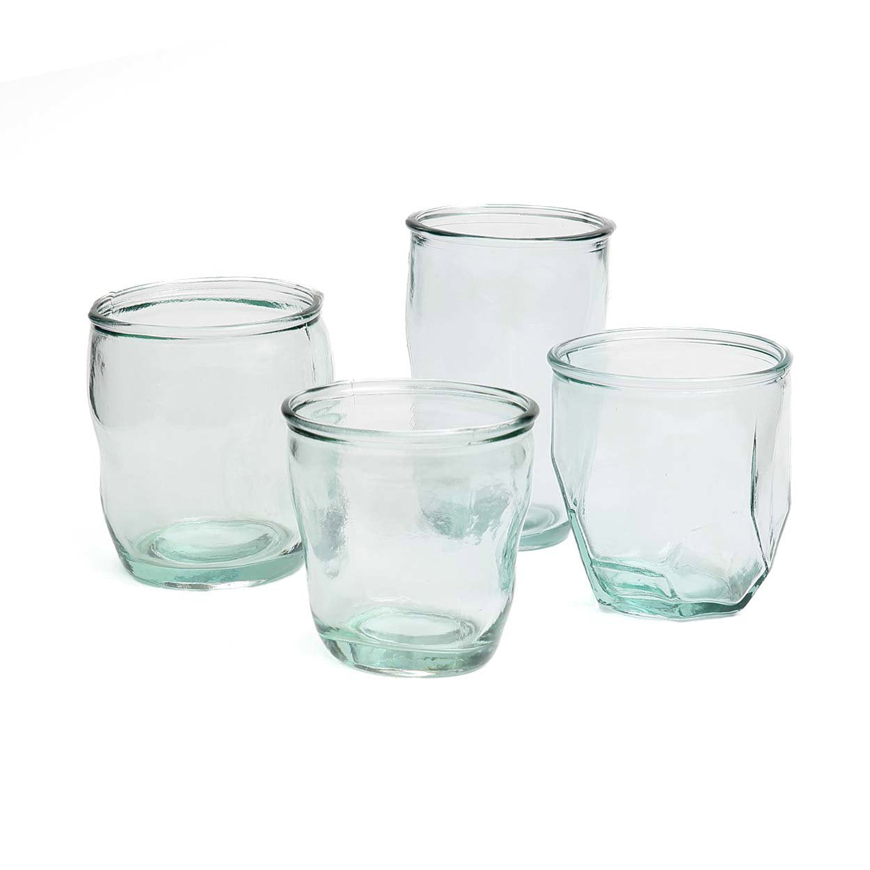 Set of four clear glass tumblers on a white background
